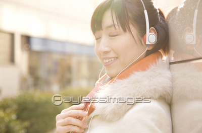 素材 人物ヘッドフォンで音楽を聴いている女性