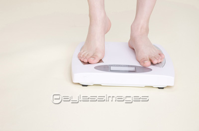 素材 人物体重を確認する女性の足元
