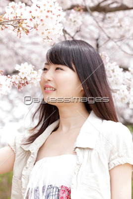 素材 人物桜の香りを嗅ぎ微笑む女性