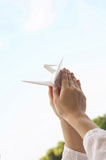 折り紙の鶴を持つ女性の手