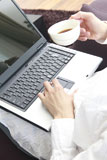 コーヒーを飲みながらノートパソコンを使う男性の手元